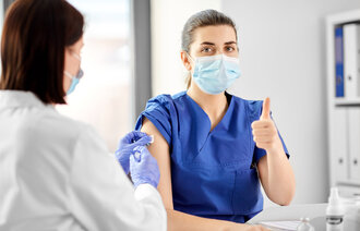 Bildet viser et helsepersonell som mottar en vaksine