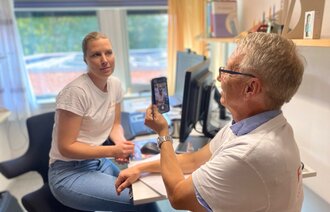 Bildet viser Jørn Hustad som tar bilde av Marianne Sjuls med mobiltelefon.