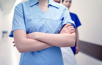 Bildet viser helsepersonell med armene i kryss.