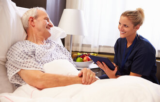 En sykepleier snakker med en pasient.