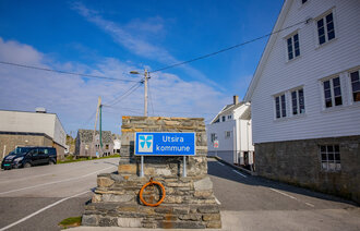 Bildet viser litt av Utsira, med et skilt der det står Utsira kommune.