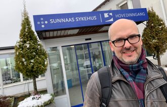 En mann foran en sykehusbygning