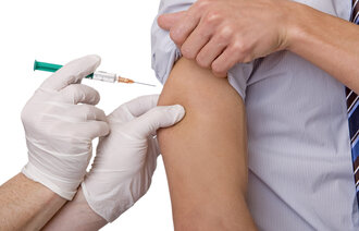 Bildet viser en person som får en medisinsk sprøyte i armen