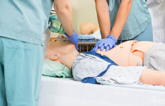 Bildet viser helsepersonell som simulererer hjerte–lunge-redning på en dukke