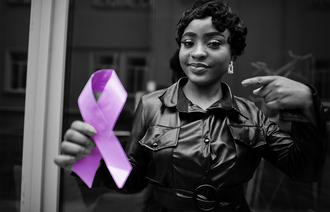 Kvinne holder opp lilla sløyfe