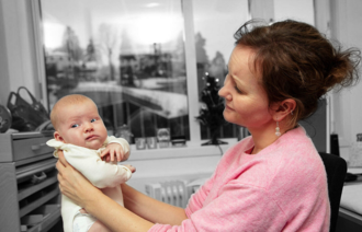 Bildet viser en helsesykepleier med en baby