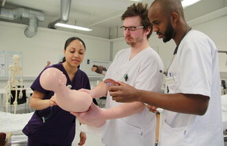 Studenter øver med en simuleringsdukke.