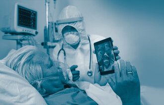 The image shows an intensive care patient with a mask communicating with his family on an iPad.
