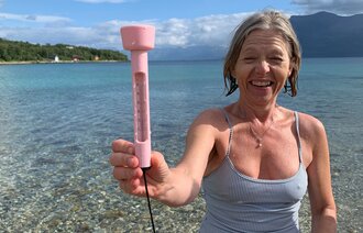 Bildet viser Torill Schneider Aarøen som isbader og holder opp et termometer