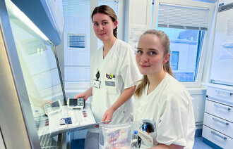 Bildet viser to kvinnelige sykepleiere som holder i medisinsk utstyr