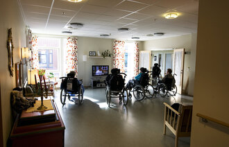 eldre i rullestol ser på tv