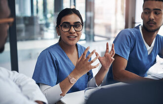 Bildet viser sykepleierstudenter som diskuterer rundt et bord