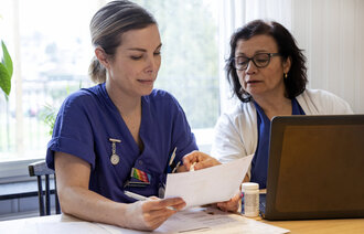 Bildet viser en sykepleierstudent som får veiledning