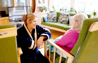  pleier i slåbrok sammen med eldre på et hjem