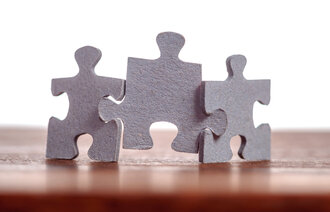 Bildet viser tre puslespillbiter som holder hverandre samlet