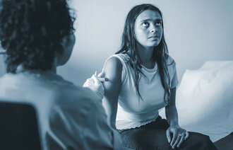 The photo shows a nurse vaccinating a young woman