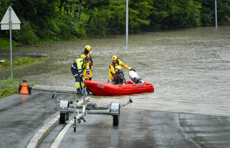 Sykepleier Ingrid-Marie Nyborg får hjelp fra redningsmannskaper til å komme seg på jobb