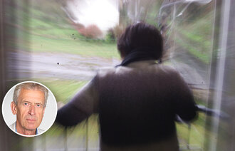 Bildet viser en kvinne bakfra som står og titter ut av vinduet.