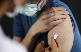 Bildet viser en kvinne som blir vaksinert