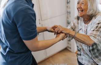 Bildet viser en sykepleier som geleider en pasient