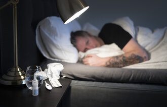 Bildet viser en mann som ligger til sengs og er syk