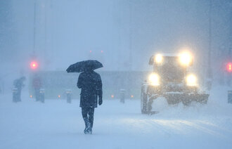 Bildet viser en mann og en brøytetraktor i et snøtett Oslo
