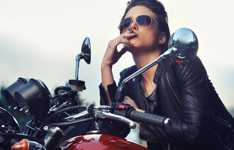 Bildet viser en dame på motorsykkel som røyker