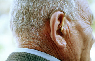 Bildet viser en eldre mann med høreapparat.