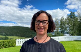 Elisabeth Sjaastad på en gressplen med blå himmel i bakgrunnen