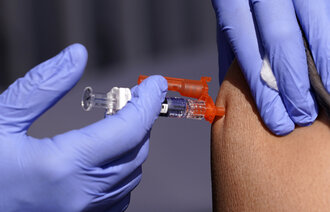 Bildet viser en sprøyte som blir satt i en skulder.