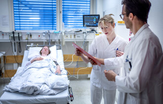 Bildet viser en sykepleier, lege og en pasient sammen