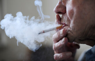 Bildet viser en eldre mann som røyker