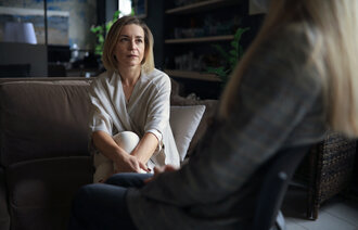 Bildet viser en kvinnelig pasient som snakker med en behandler