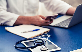 Bildet viser en hånd som holder i en mobiltelefon.