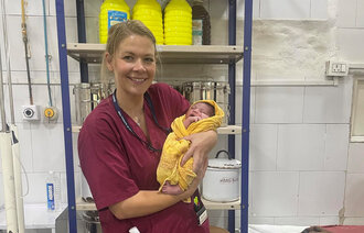 Bildet viser jordmor Martine Topaas Billington med et nyfødt barn i India