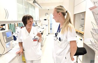 Bildet vider til sykepleiere som står på medisinrommet og snakker