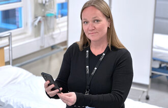 Bildet viser innleggsforfatteren som holder en mobil