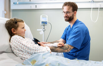 Bildet viser sykepleier Lars Pilskog med en pasient