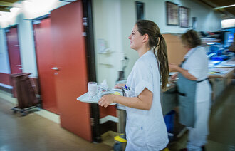 Bildet viser sykepleier i sykehuskorridor