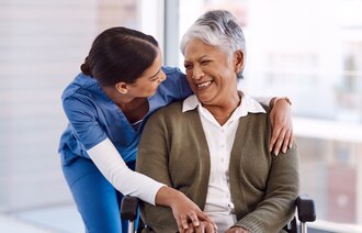 Bildet viser en sykepleier som viser omsorg for en eldre pasient med innvandrerbakgrunn