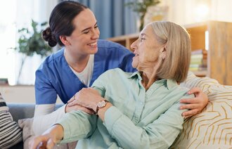 Bildet viser en sykepleier som holder rundt en dødssyk kreftpasient