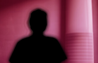 Bilde viser silluett av et menneske på rød bakgrunn