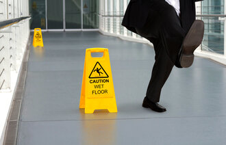 Bildet viser mann som faller på vått gulv