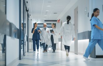 Bildet viser et tverrprofesjonelt team som går i gangen på et sykehus