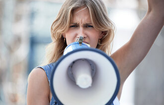 Bildet viser en ung, blond kvinne som holder en ropert foran seg