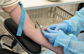 Bildet viser sykepleier som tar blodprøve.