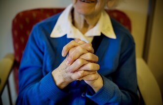 Illustrasjonsbilde av eldre dame med foldede hender.