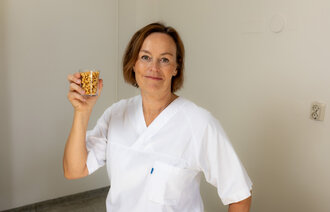 Bildet viser Liv Bjerke Rodal med et glass med peanøtter.