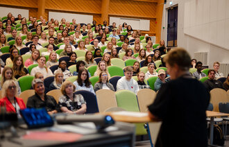 Bildet viser studieprogramleder Kristin Haugen foran ferske sykepleierstudenter på NTNU Gjøvik.