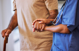 Bildet viser sykepleier som geleider eldre pasient